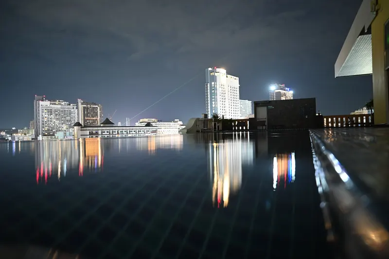 Rooftop infinity pool reflecting city lights at night